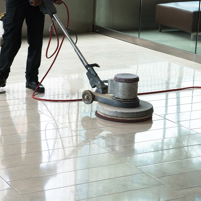 A man cleaning a floor with a machine.