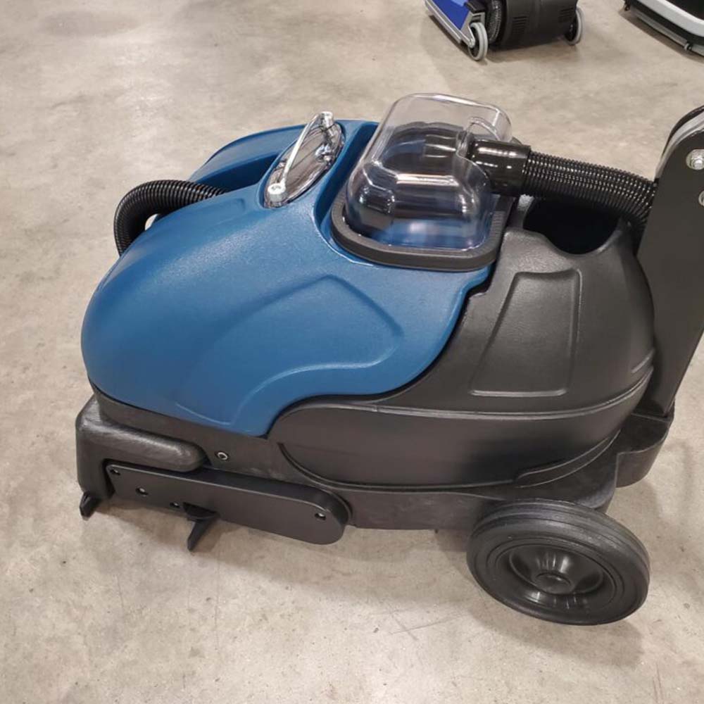 A blue and black vacuum cleaner sitting in a warehouse.