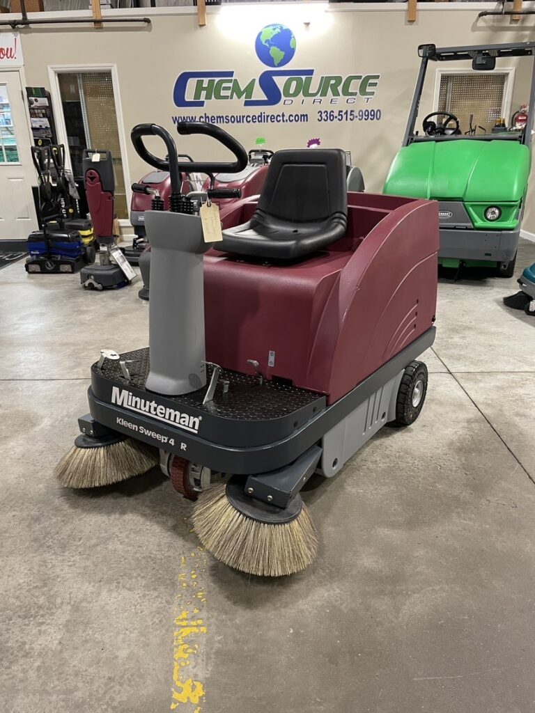 A Minuteman Kleen Sweep 47R Rider Sweeper in a warehouse showroom.