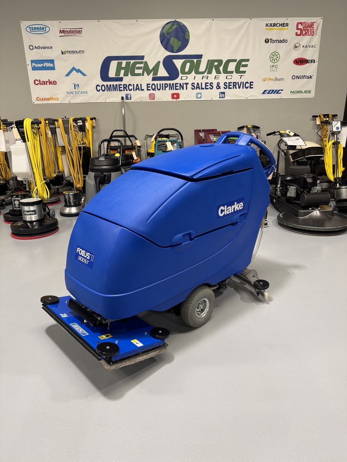 A Clarke Focus II Boost 28" Orbital Scrubber in a warehouse showroom at ChemSource Direct.