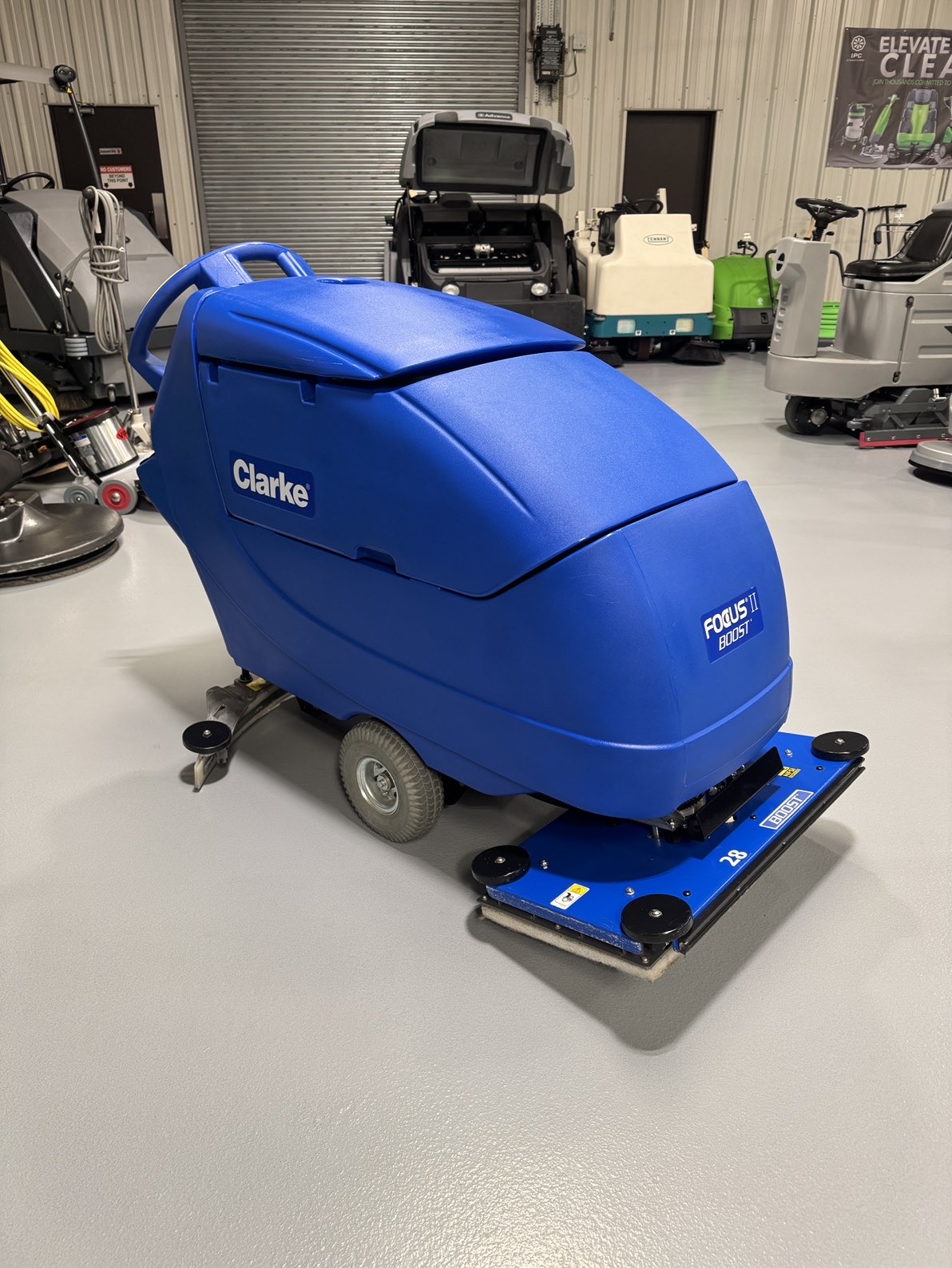 A Clarke Focus II Boost 28" Orbital Scrubber in a warehouse showroom at ChemSource Direct.