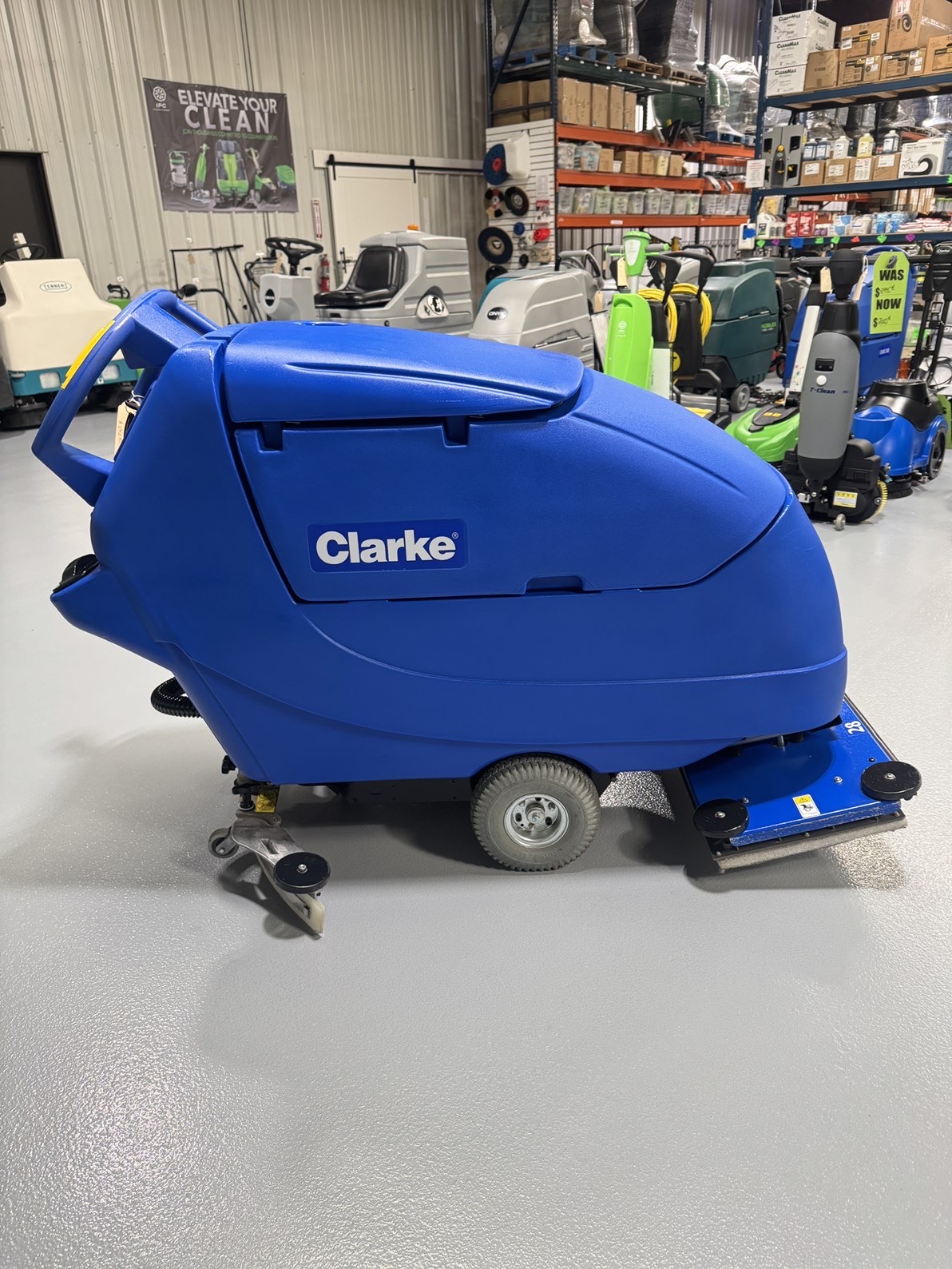 A Clarke Focus II Boost 28" Orbital Scrubber in a warehouse showroom at ChemSource Direct.