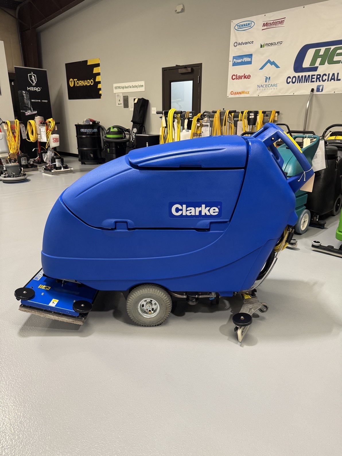 A Clarke Focus II Boost 28" Orbital Scrubber in a warehouse showroom at ChemSource Direct.