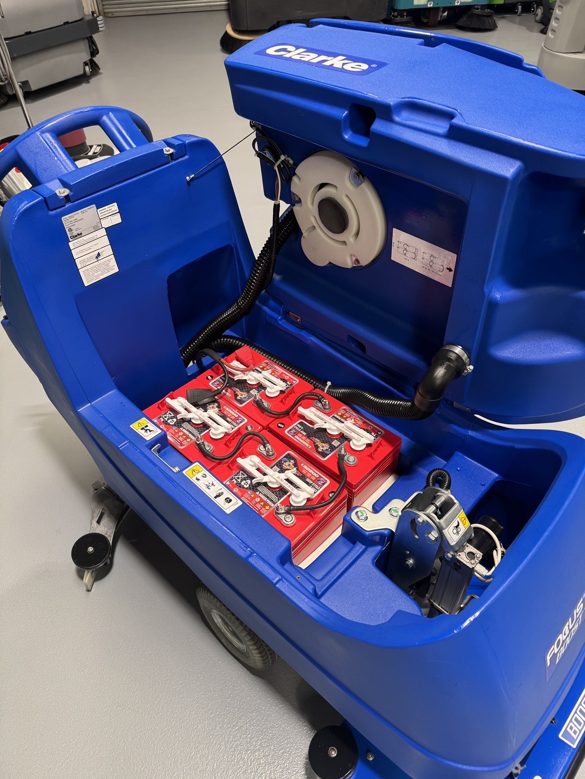 A Clarke Focus II Boost 28" Orbital Scrubber in a warehouse showroom at ChemSource Direct.