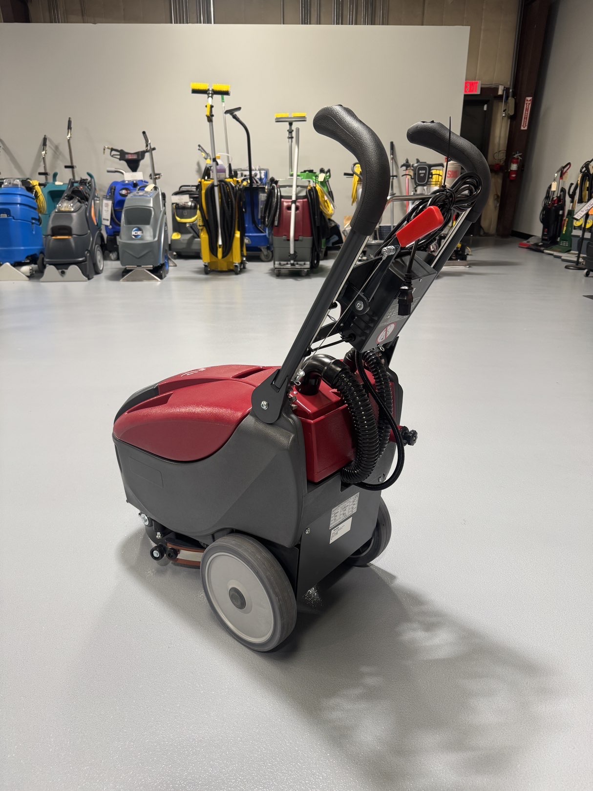 A Minuteman E14 Walk-Behind Scrubber in a warehouse showroom at ChemSource Direct.