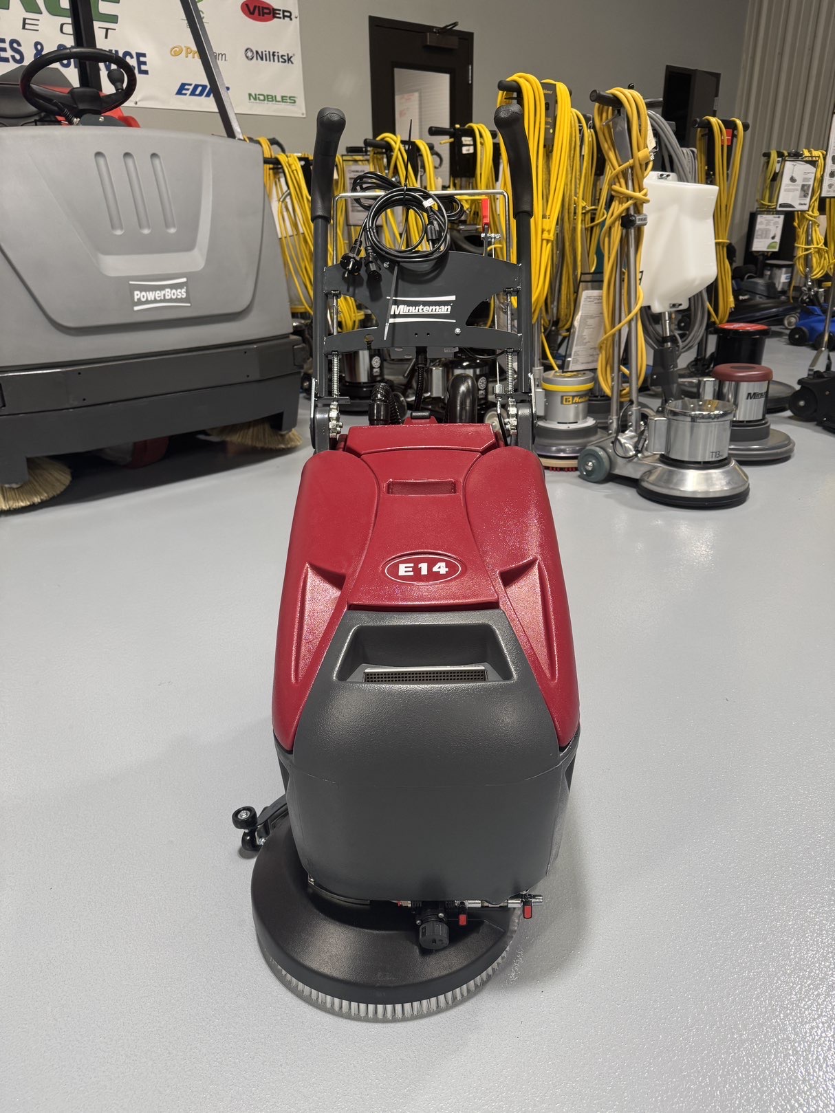 A Minuteman E14 Walk-Behind Scrubber in a warehouse showroom at ChemSource Direct.
