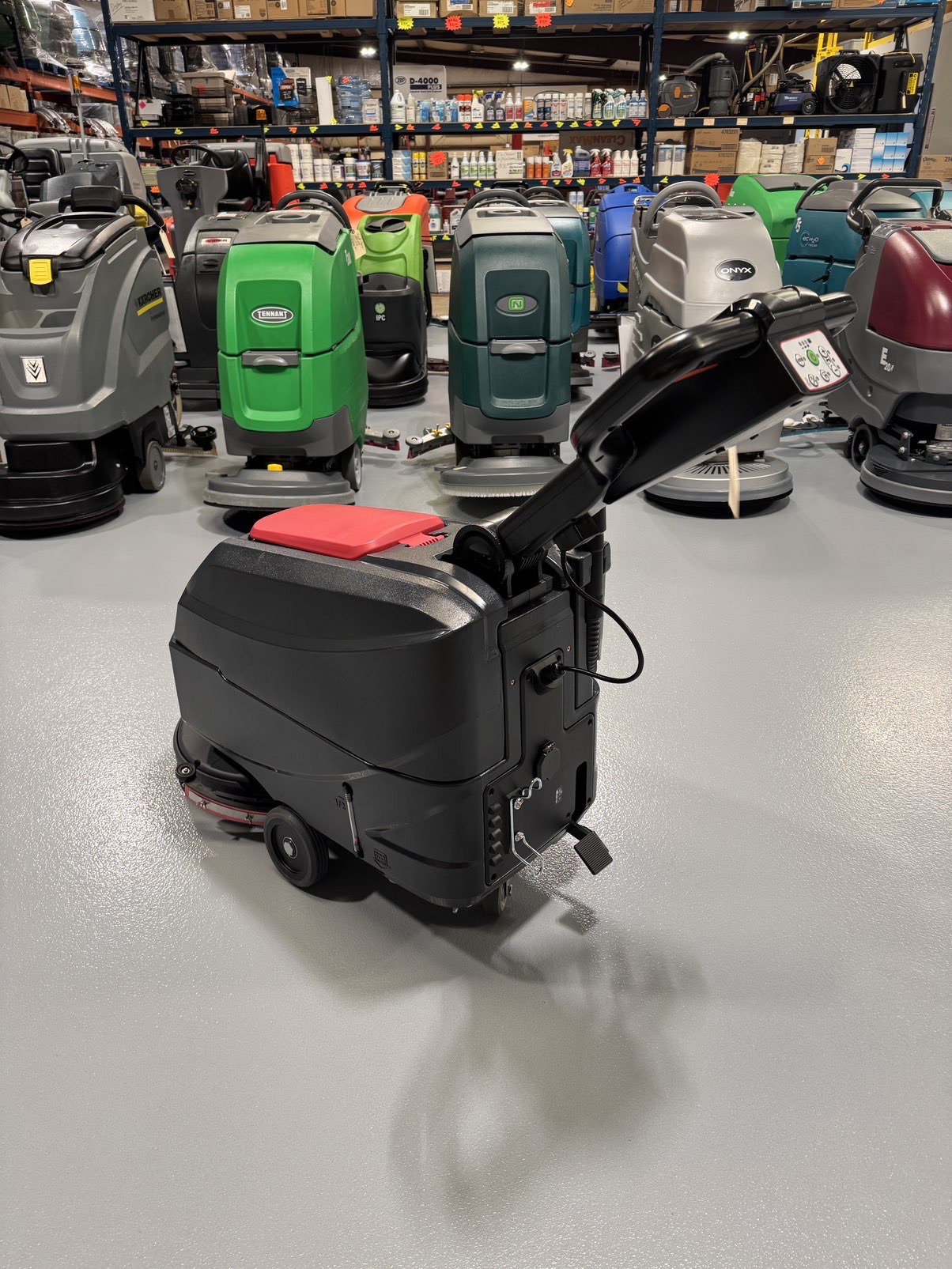 A Viper AS4325B 17" Walk-Behind Scrubber in a warehouse showroom at ChemSource Direct.