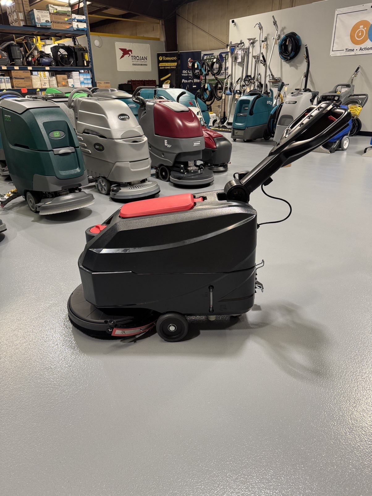 A Viper AS4325B 17" Walk-Behind Scrubber in a warehouse showroom at ChemSource Direct.
