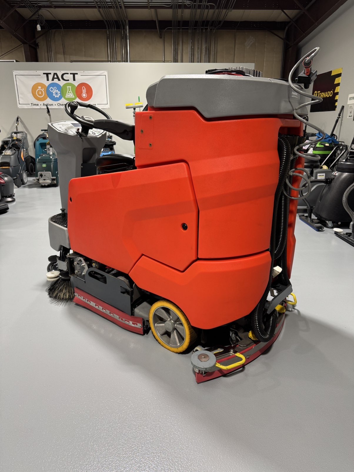 A PowerBoss Scrubmaster B175 Cylindrical Ride-On Scrubber in a warehouse showroom at ChemSource Direct.