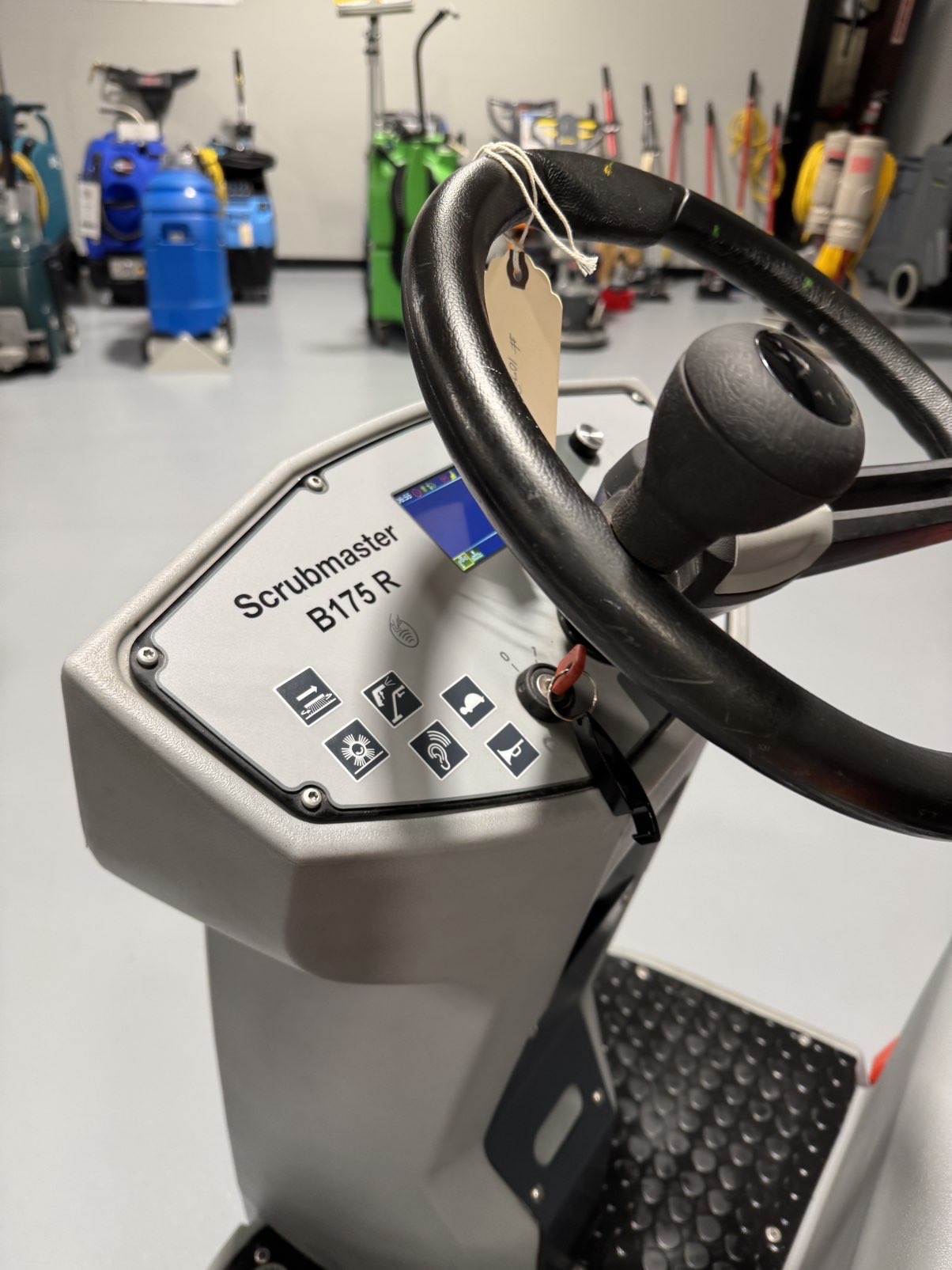 A PowerBoss Scrubmaster B175 Cylindrical Ride-On Scrubber in a warehouse showroom at ChemSource Direct.