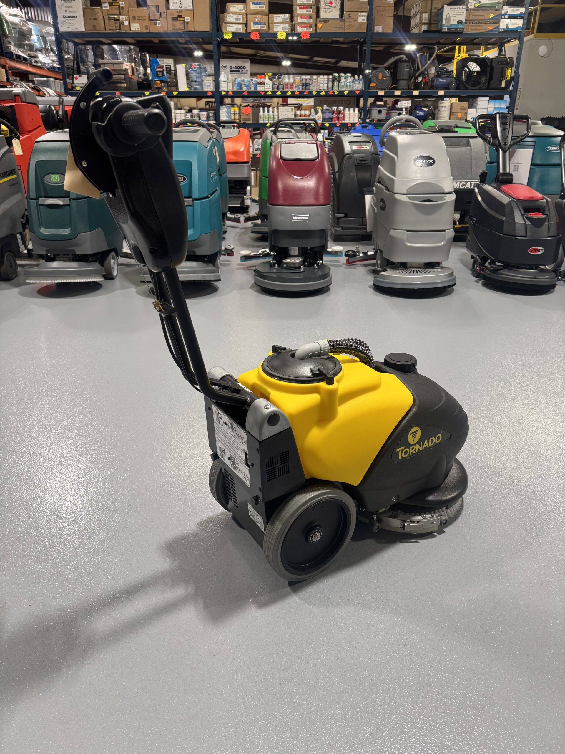 Tornado BD 14/4 14" Walk-Behind Scrubber in a warehouse showroom at ChemSource Direct.