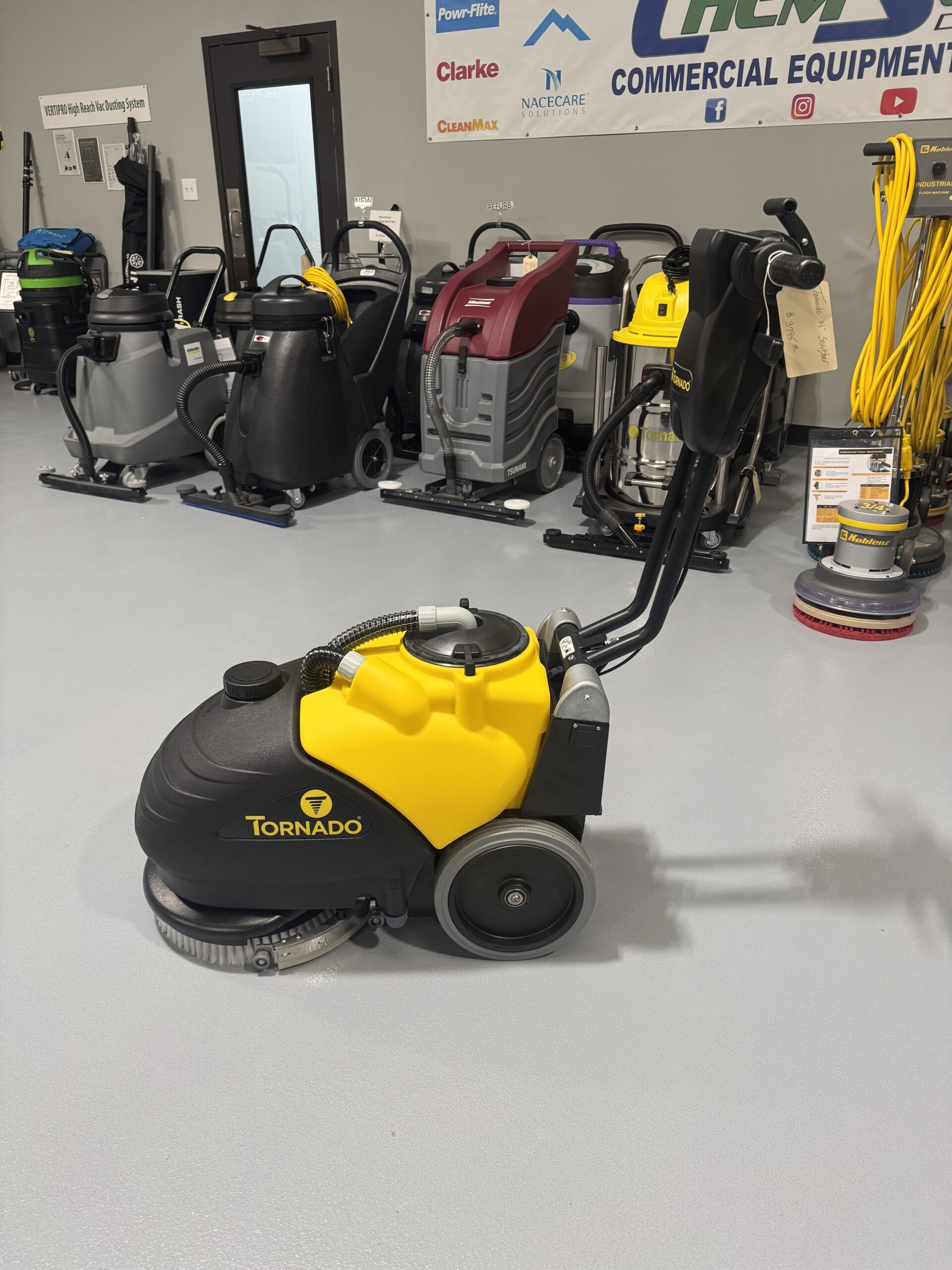 Tornado BD 14/4 14" Walk-Behind Scrubber in a warehouse showroom at ChemSource Direct.