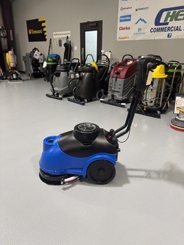 A Clarke MA50 15" Walk-Behind Scrubber in a warehouse showroom at ChemSource Direct.
