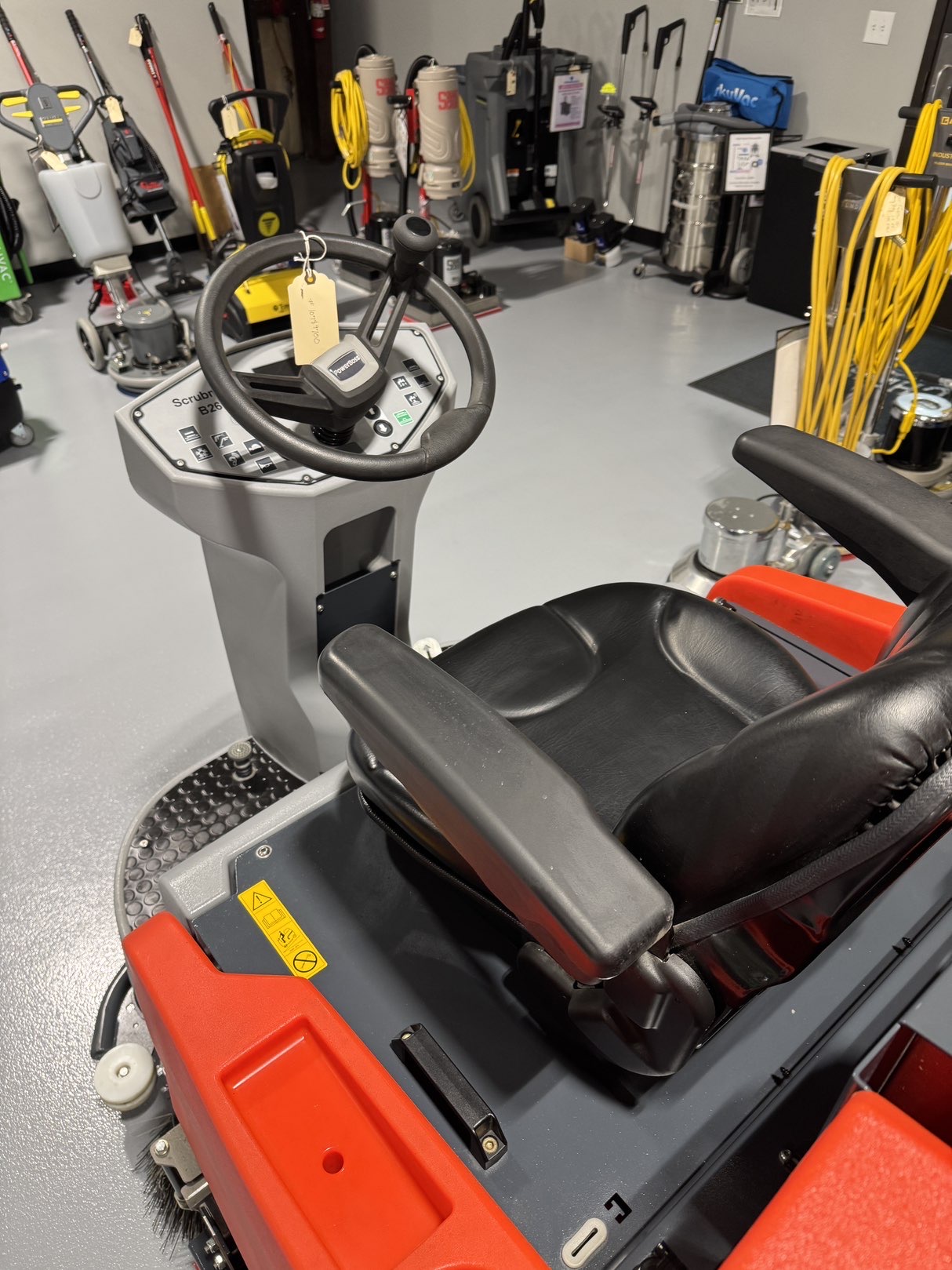 A Powerboss B260R Cylindrical Ride-On Scrubber in a warehouse showroom at ChemSource Direct.