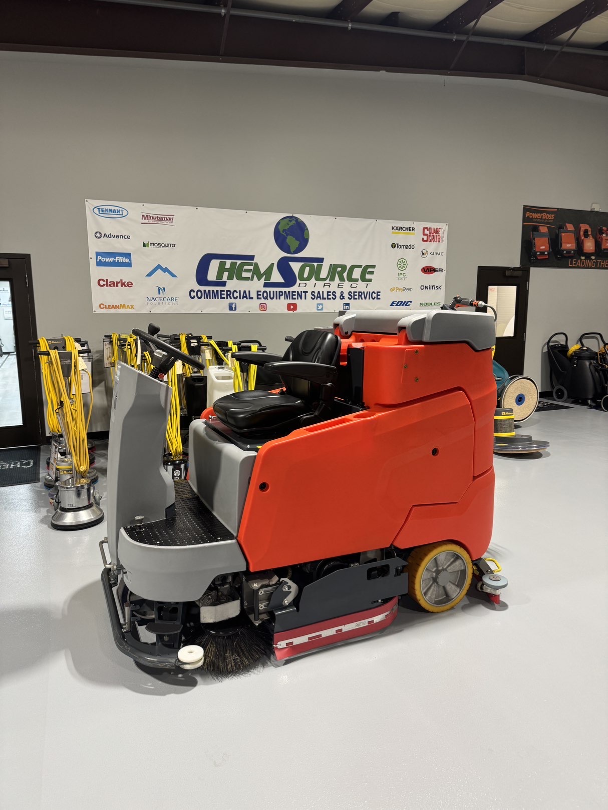 A Powerboss B260R Cylindrical Ride-On Scrubber in a warehouse showroom at ChemSource Direct.