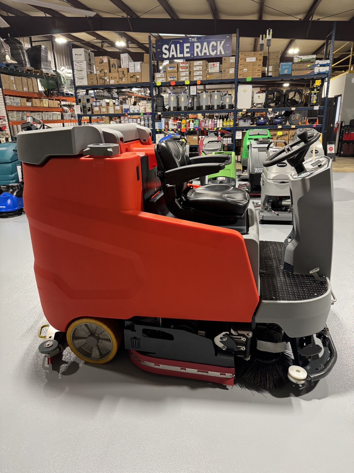 A Powerboss B260R Cylindrical Ride-On Scrubber in a warehouse showroom at ChemSource Direct.