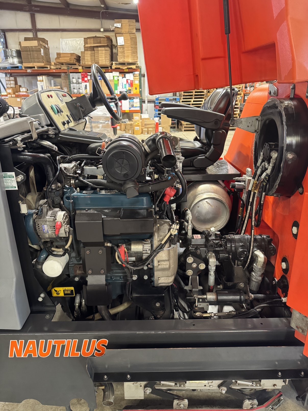 A Powerboss Nautilus PB45LP Ride-On Scrubber in a warehouse showroom at ChemSource Direct.