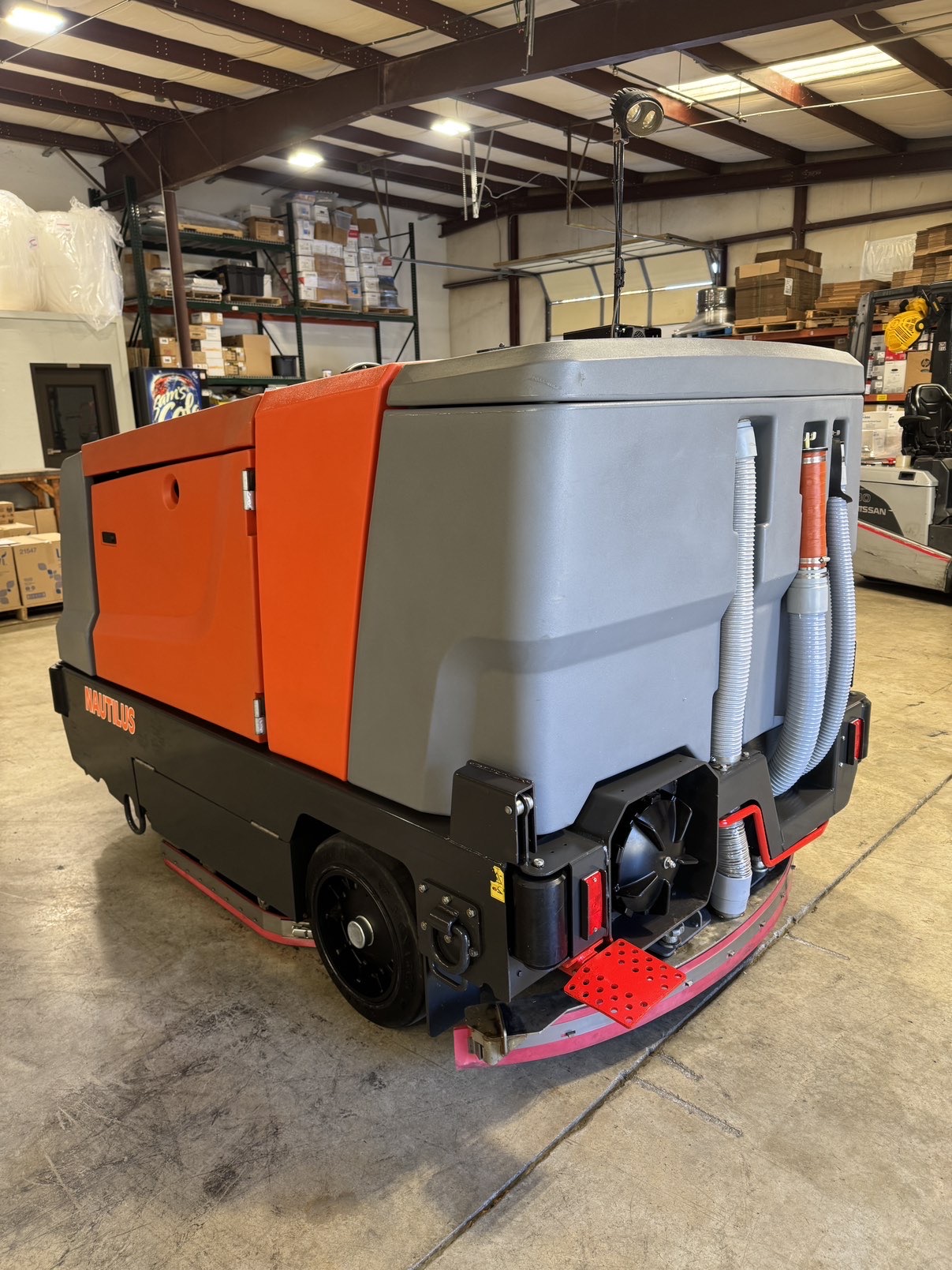 A Powerboss Nautilus PB45LP Ride-On Scrubber in a warehouse showroom at ChemSource Direct.