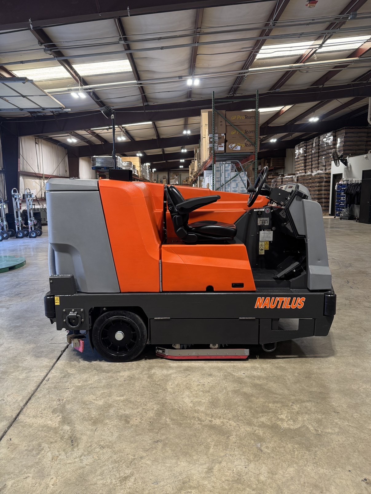 A Powerboss Nautilus PB45LP Ride-On Scrubber in a warehouse showroom at ChemSource Direct.