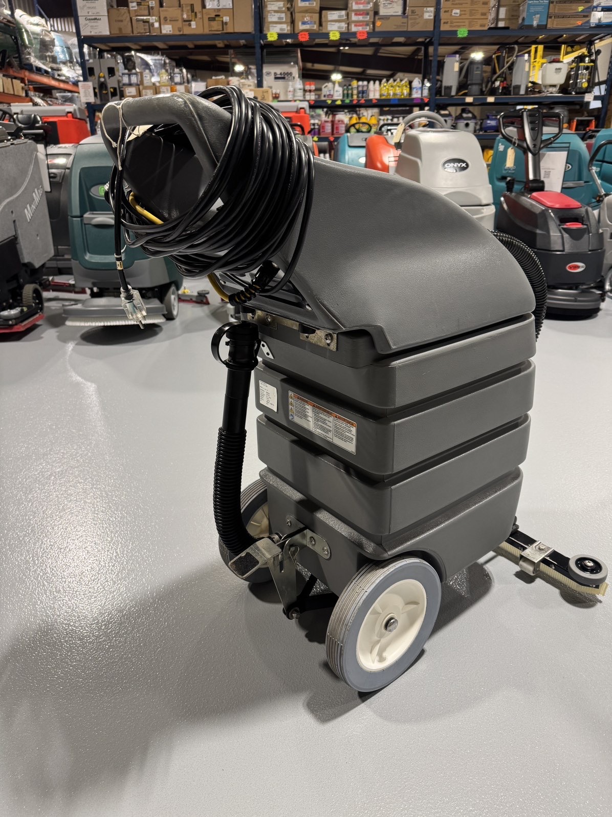 A Tennant V-WD-15 15 Gallon Wet/Dry Vacuum in a warehouse showroom at ChemSource Direct.