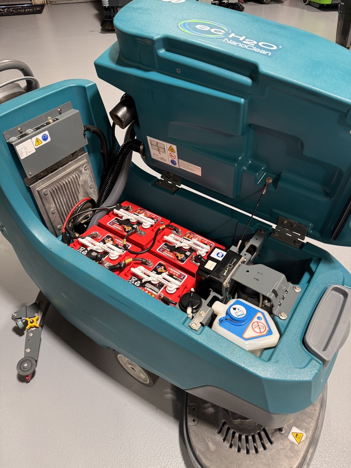 A Tennant T500 Walk-Behind Scrubber in a warehouse showroom at ChemSource Direct.