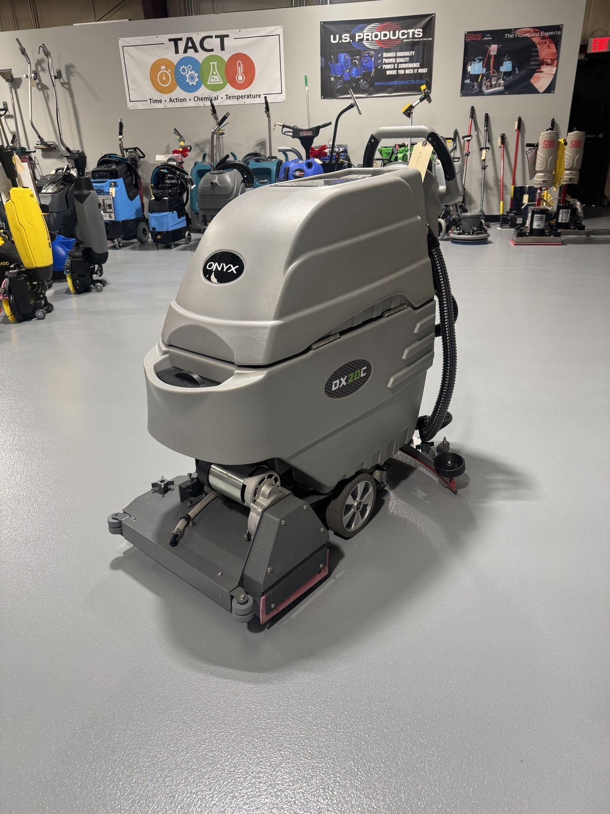 An Onyx DX20C Cylindrical Walk-Behind Scrubber in a warehouse showroom at ChemSource Direct.