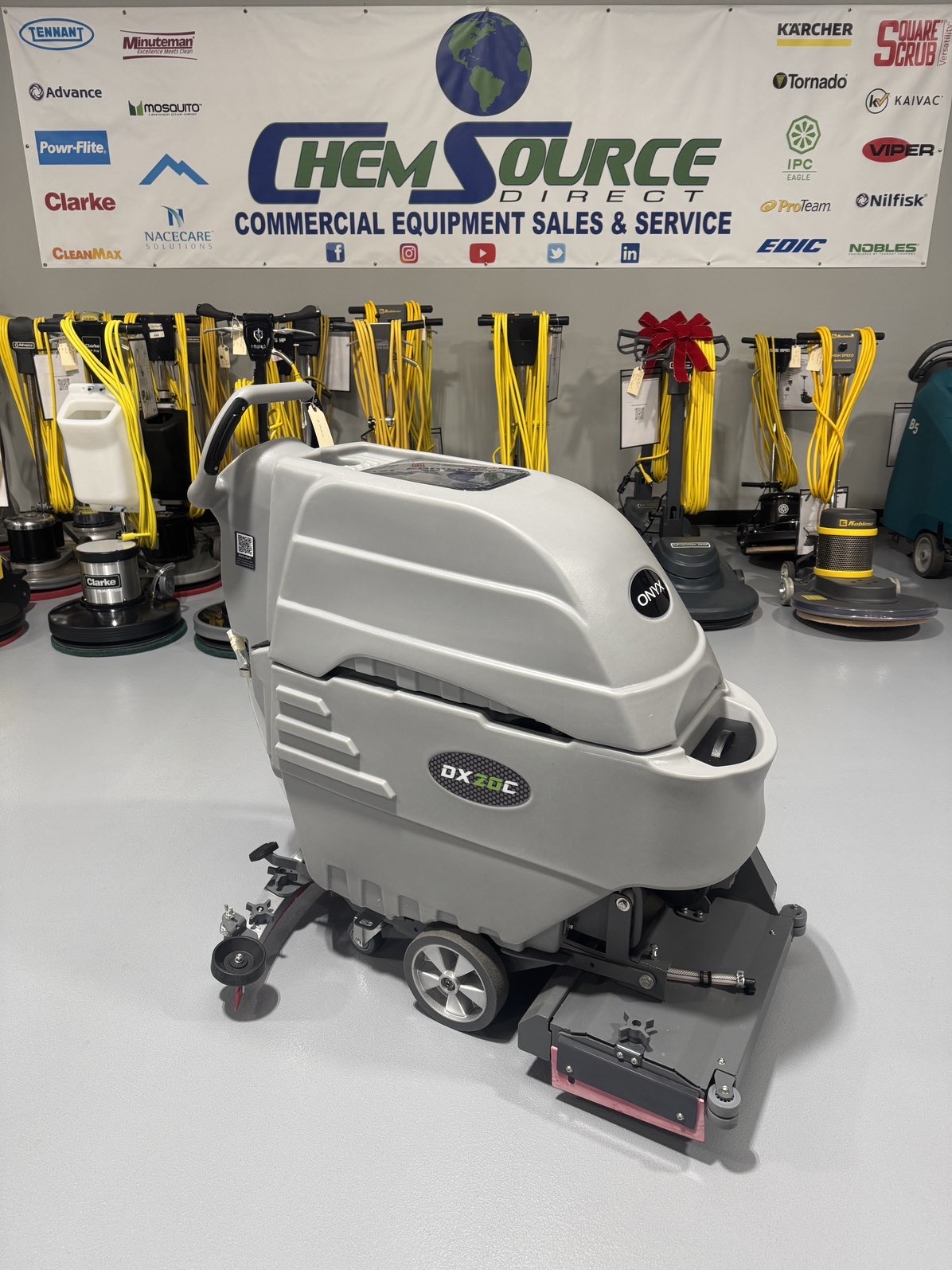 An Onyx DX20C Cylindrical Walk-Behind Scrubber in a warehouse showroom at ChemSource Direct.
