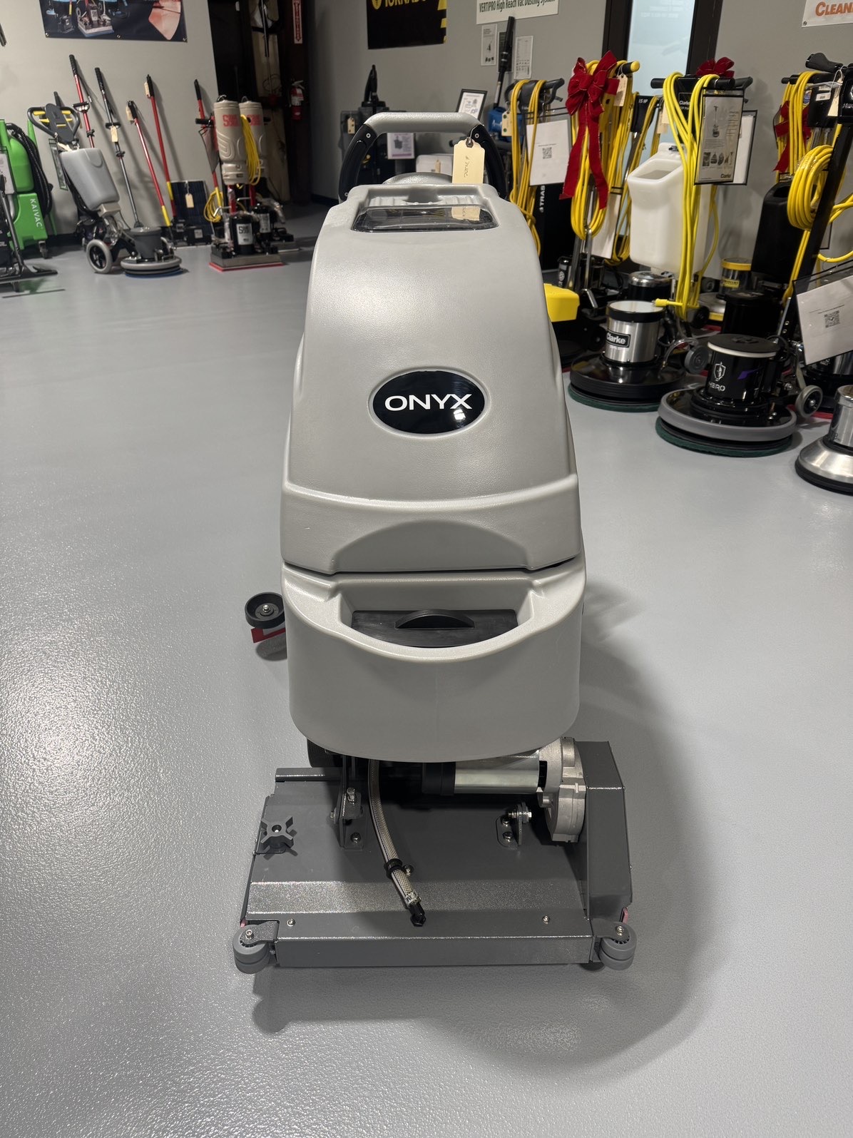 An Onyx DX20C Cylindrical Walk-Behind Scrubber in a warehouse showroom at ChemSource Direct.