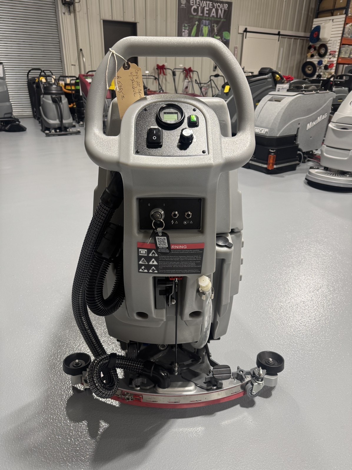 An Onyx DX20C Cylindrical Walk-Behind Scrubber in a warehouse showroom at ChemSource Direct.
