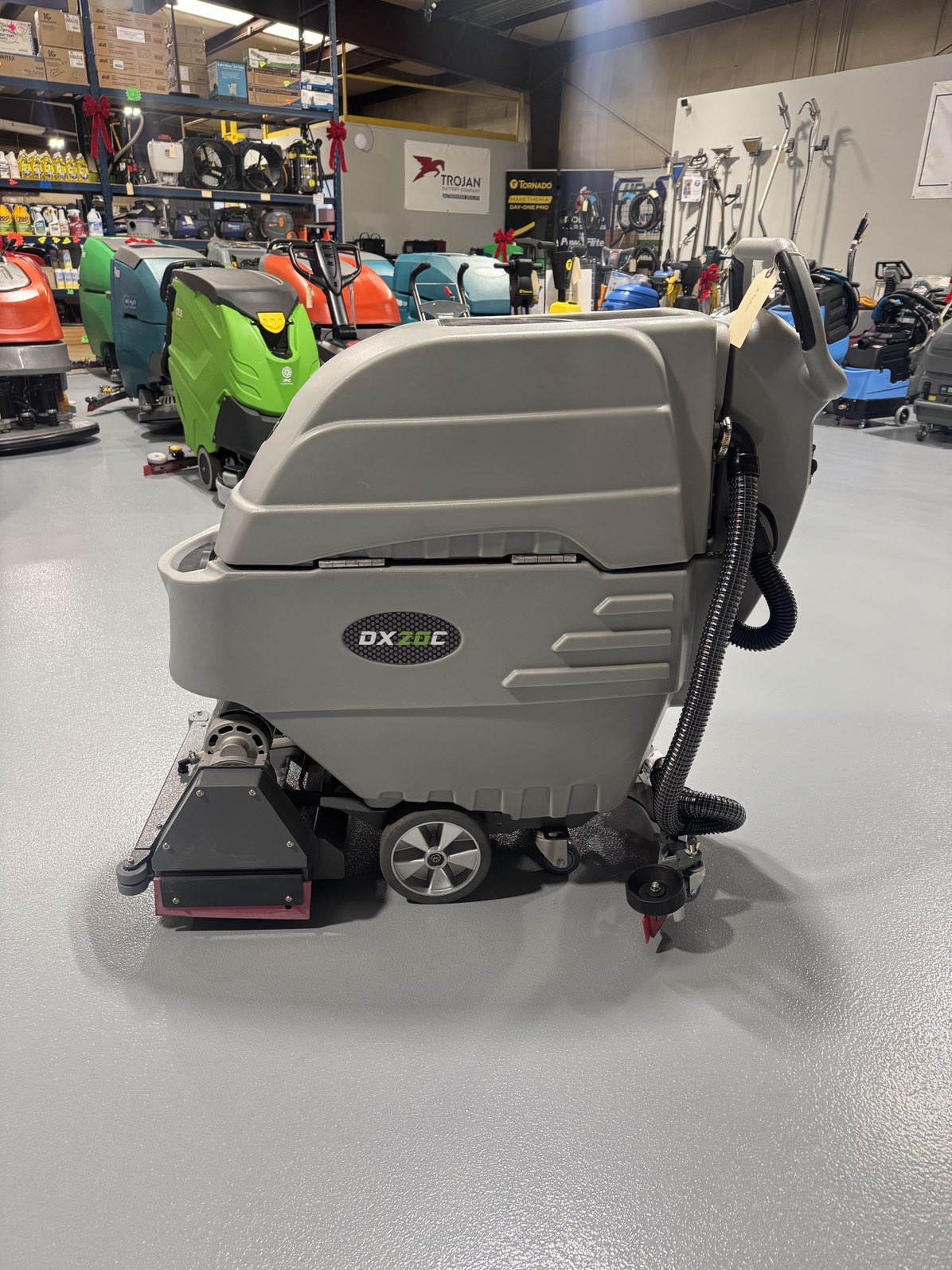 An Onyx DX20C Cylindrical Walk-Behind Scrubber in a warehouse showroom at ChemSource Direct.