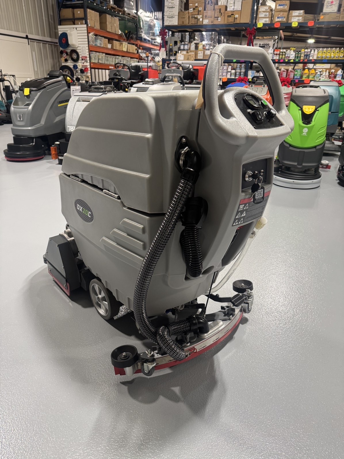 An Onyx DX20C Cylindrical Walk-Behind Scrubber in a warehouse showroom at ChemSource Direct.
