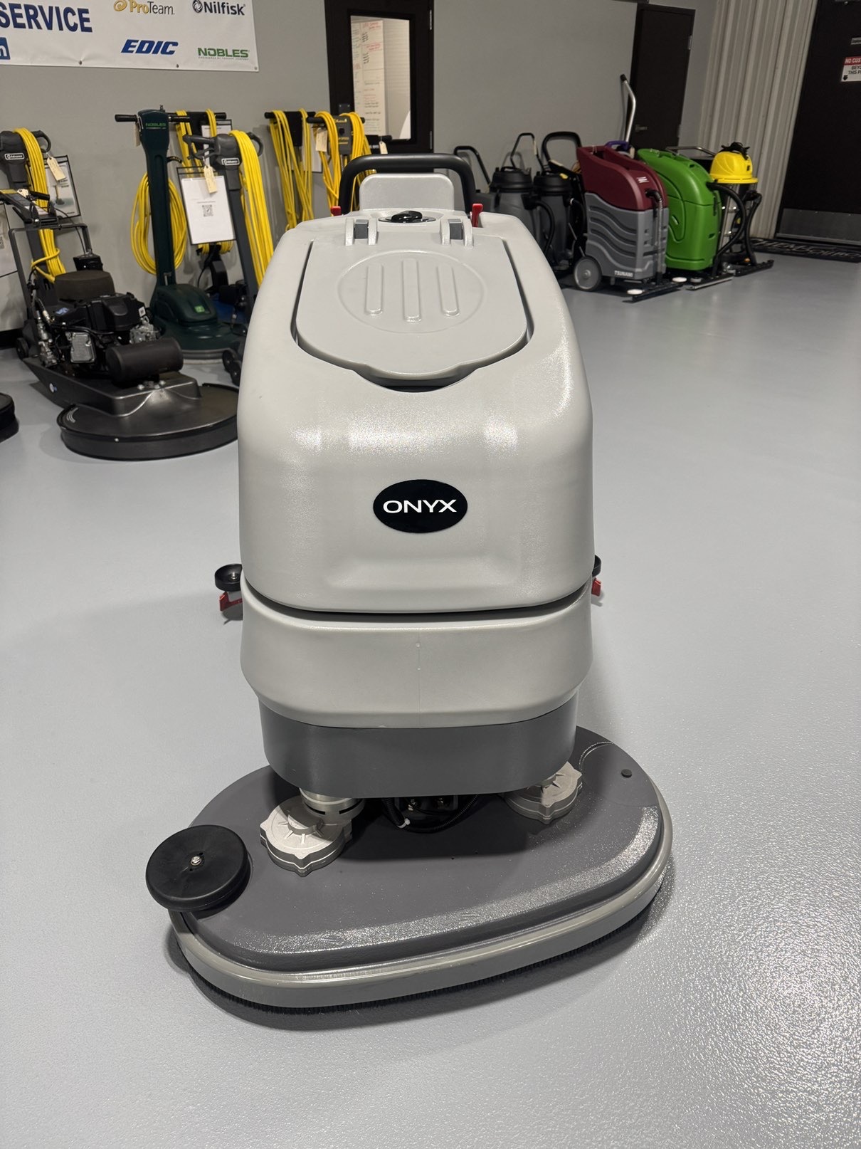 An Onyx DX32T Walk-Behind Scrubber in a warehouse showroom at ChemSource Direct.