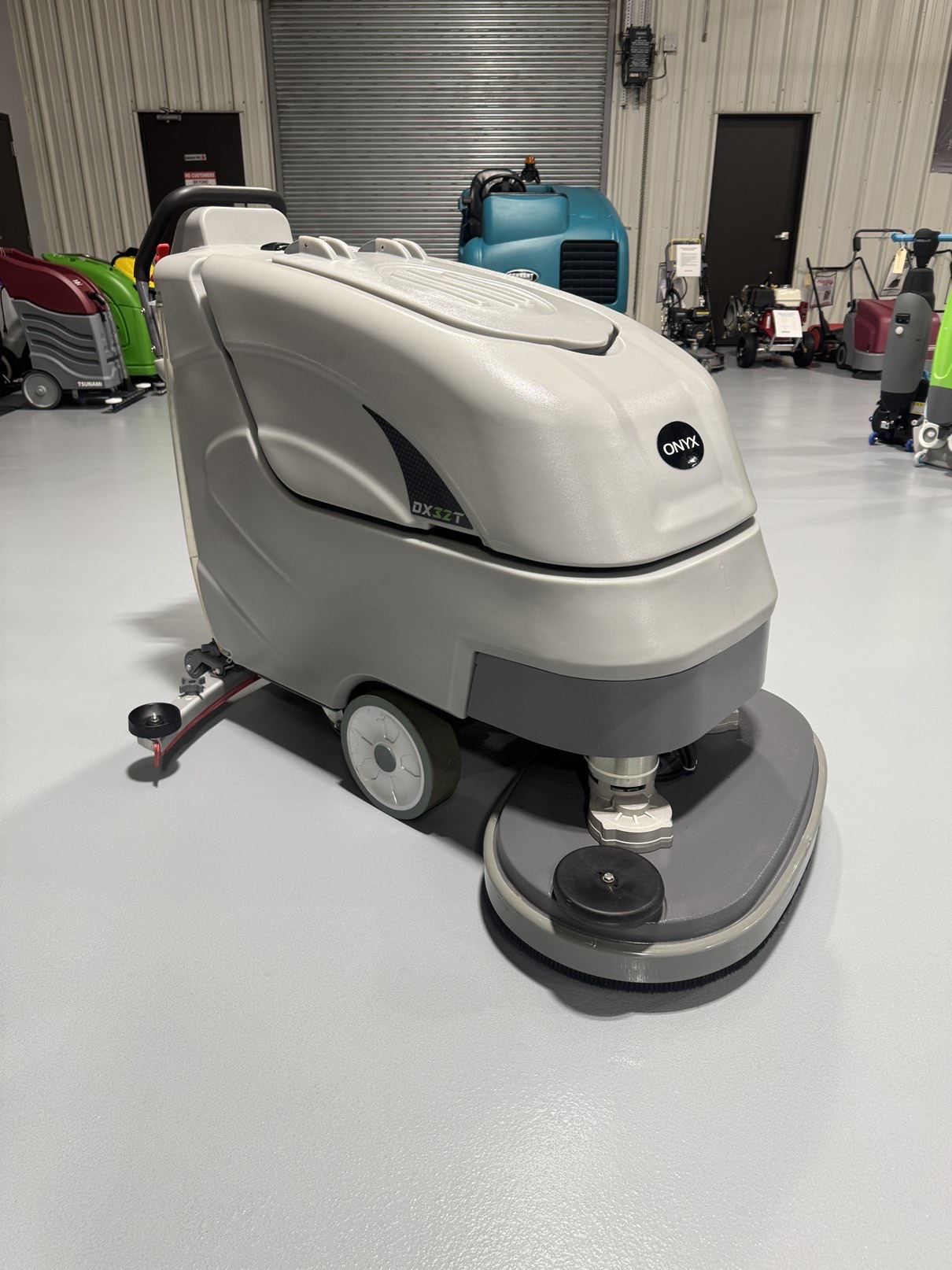 An Onyx DX32T Walk-Behind Scrubber in a warehouse showroom at ChemSource Direct.