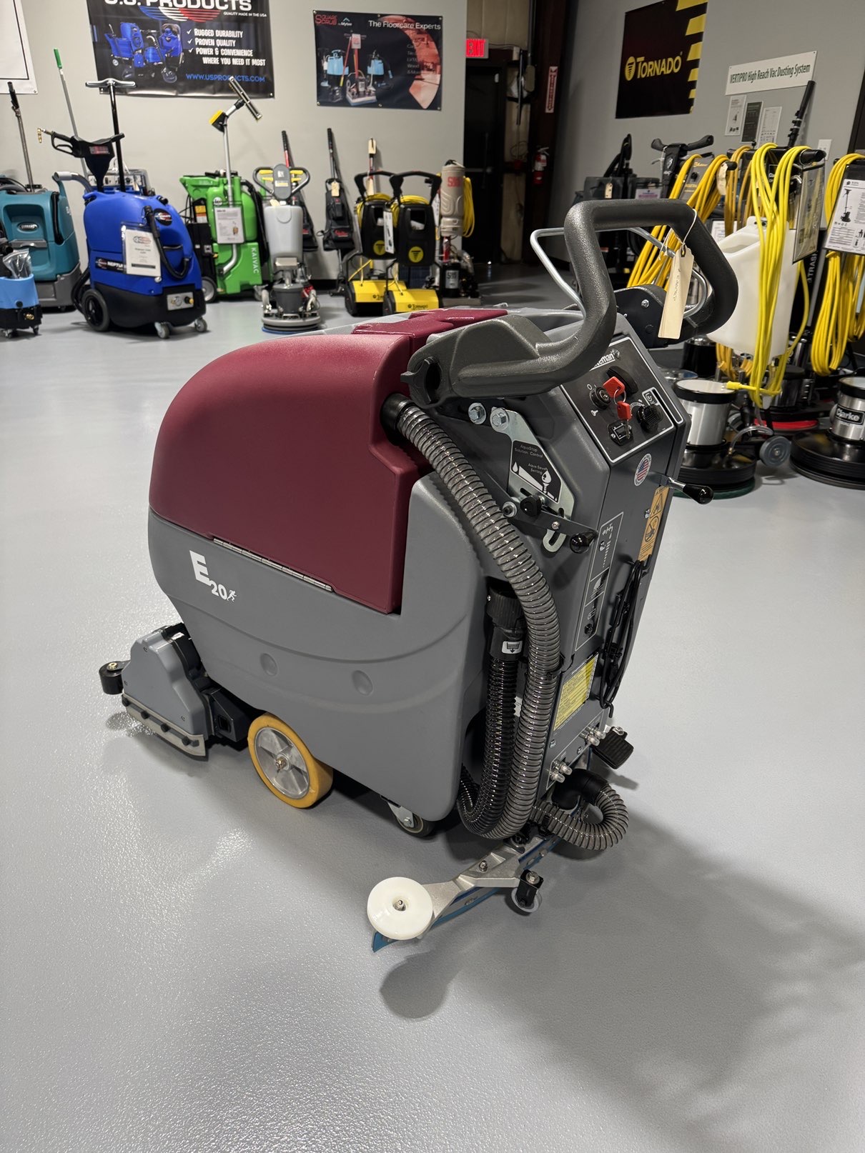 A Minuteman E20CQP Walk-Behind Scrubber in a warehouse showroom at ChemSource Direct.