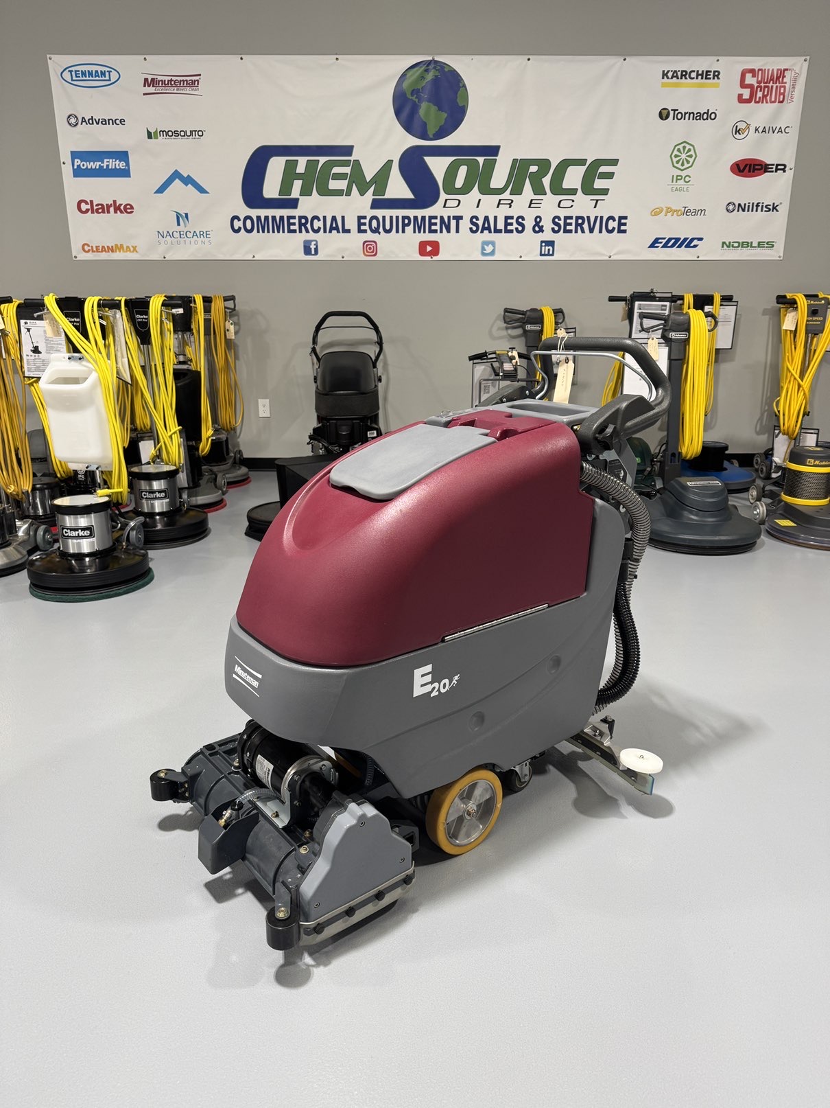 A Minuteman E20CQP Walk-Behind Scrubber in a warehouse showroom at ChemSource Direct.