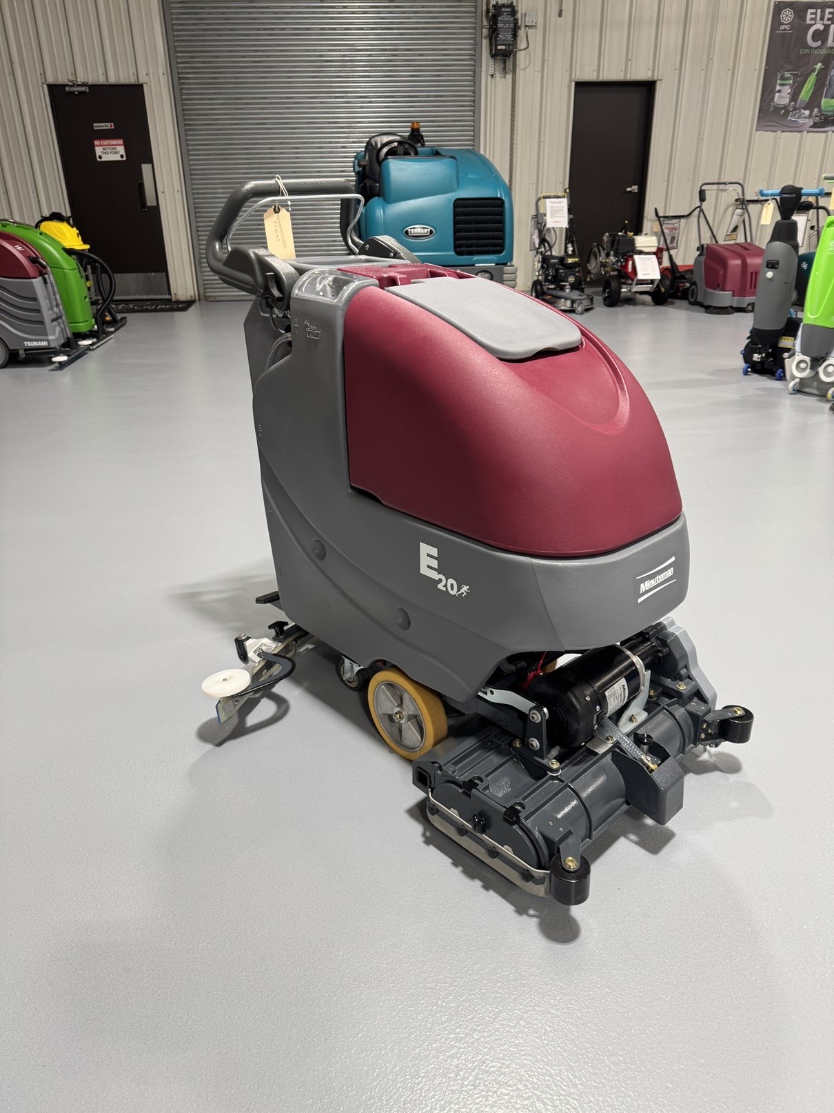A Minuteman E20CQP Walk-Behind Scrubber in a warehouse showroom at ChemSource Direct.
