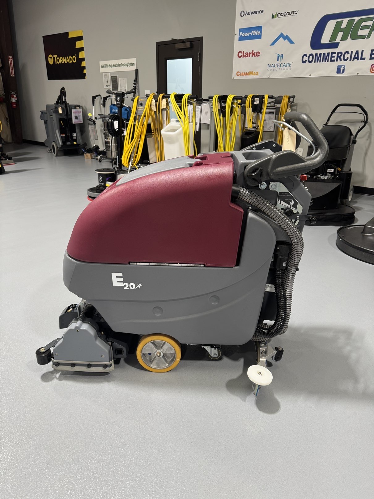 A Minuteman E20CQP Walk-Behind Scrubber in a warehouse showroom at ChemSource Direct.