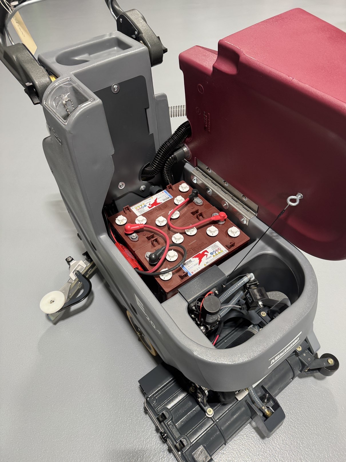 A Minuteman E20CQP Walk-Behind Scrubber in a warehouse showroom at ChemSource Direct.