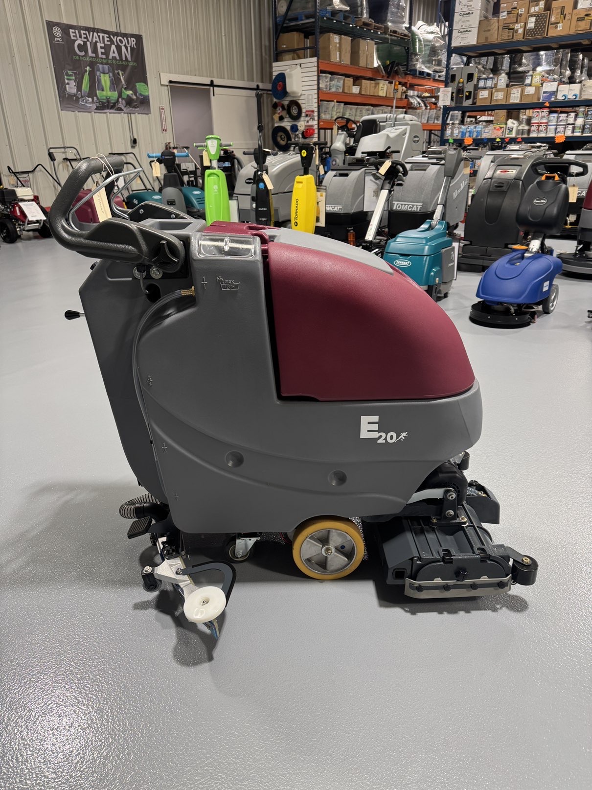 A Minuteman E20CQP Walk-Behind Scrubber in a warehouse showroom at ChemSource Direct.