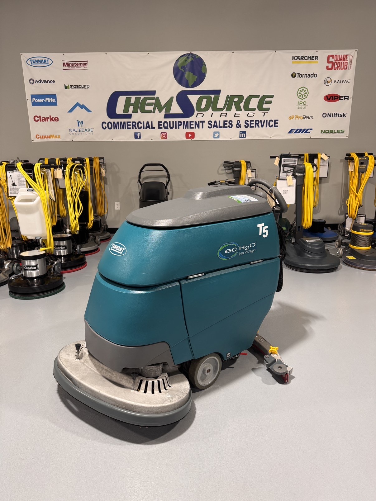 A Tennant T5 32D Disc Walk-Behind Scrubber in a warehouse showroom at ChemSource Direct.