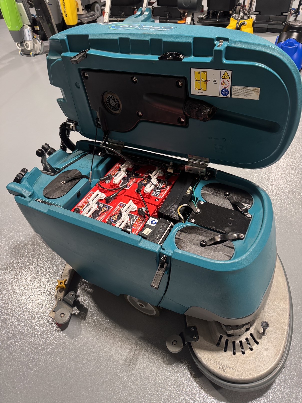 A Tennant T5 32D Disc Walk-Behind Scrubber in a warehouse showroom at ChemSource Direct.