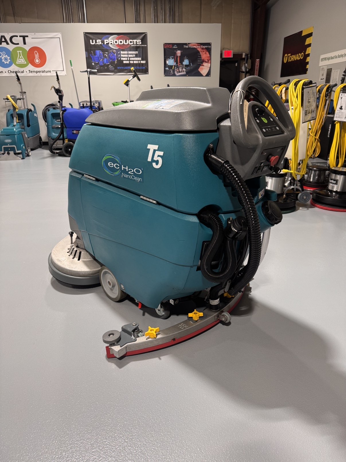 A Tennant T5 32D Disc Walk-Behind Scrubber in a warehouse showroom at ChemSource Direct.