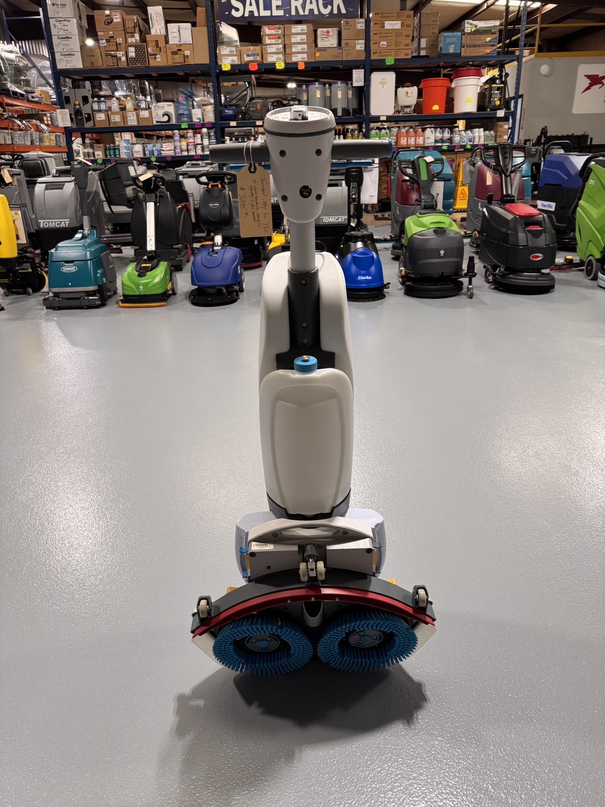 A Tennant iMop XL Plus Walk-Behind Scrubber in a warehouse showroom at ChemSource Direct.