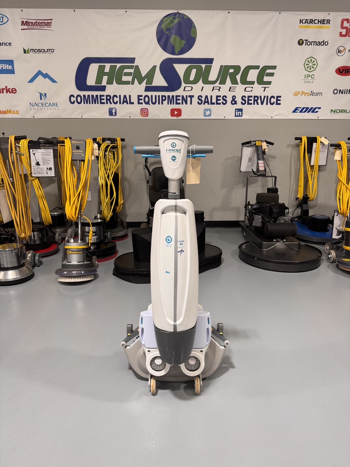 A Tennant iMop XL Plus Walk-Behind Scrubber in a warehouse showroom at ChemSource Direct.