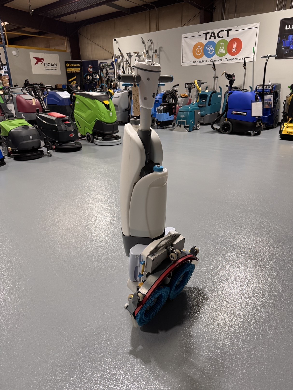 A Tennant iMop XL Plus Walk-Behind Scrubber in a warehouse showroom at ChemSource Direct.