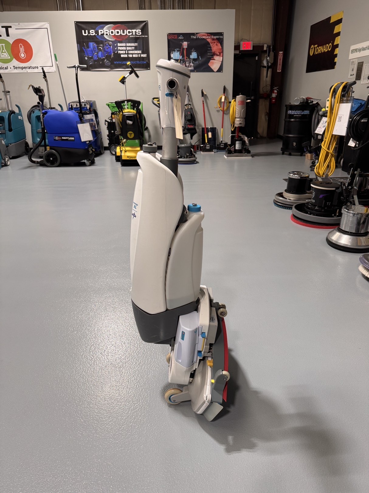 A Tennant iMop XL Plus Walk-Behind Scrubber in a warehouse showroom at ChemSource Direct.