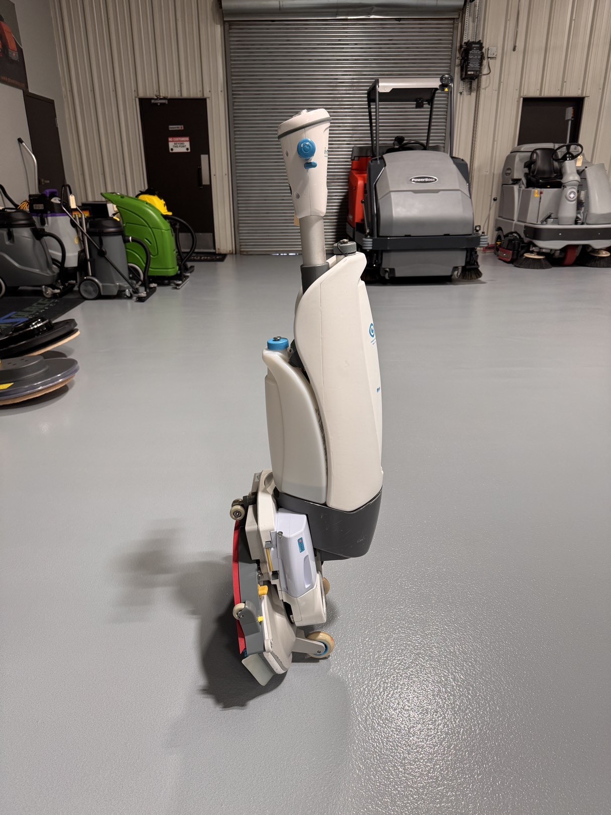 A Tennant iMop XL Plus Walk-Behind Scrubber in a warehouse showroom at ChemSource Direct.
