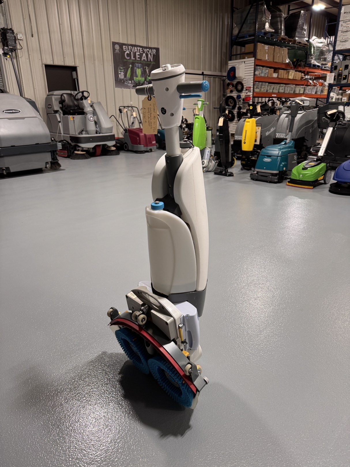 A Tennant iMop XL Plus Walk-Behind Scrubber in a warehouse showroom at ChemSource Direct.