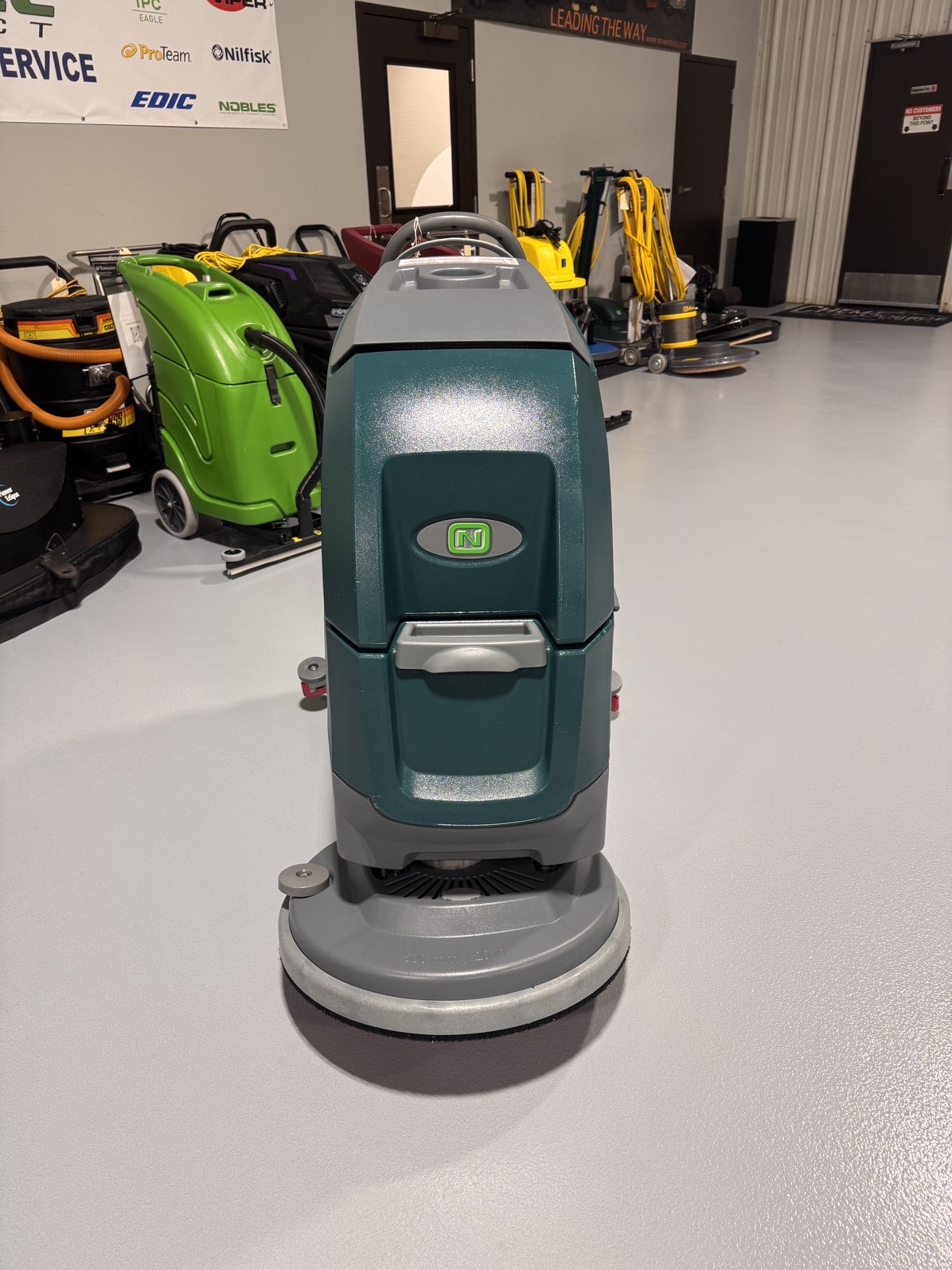 A Nobles SpeedScrub 300 Walk-Behind Scrubber in a warehouse showroom at ChemSource Direct.