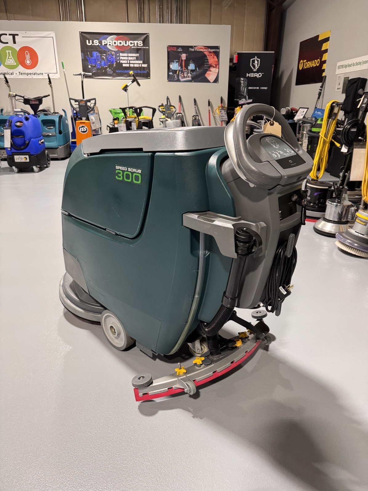 A Nobles SpeedScrub 300 Walk-Behind Scrubber in a warehouse showroom at ChemSource Direct.
